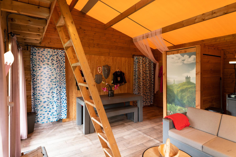 Interno della tenda safari Ridder & Prinsessen huisje con arredi in legno e tema castello nei Paesi Bassi.