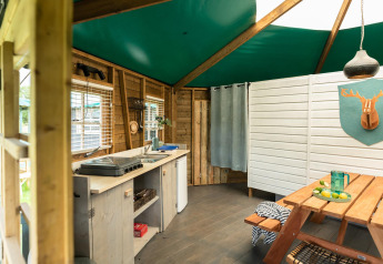 Interno del Forest cottage al Beloofde Land, Paesi Bassi, con cucina in legno e tavolo da picnic.