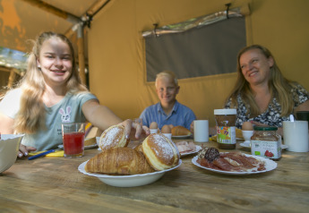 Family having breakfast with pastries, spreads, and juice at SunLodge Bintulu, Camping Village Poljana, Croatia.