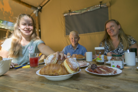 Familia desayunando con bollería y embutidos en SunLodge Bintulu, Camping Village Poljana, Croacia.