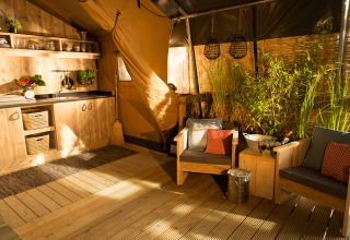 Acogedora área interior SunLodge Bintulu en Camping Village Poljana, Croacia, con muebles rústicos y plantas.
