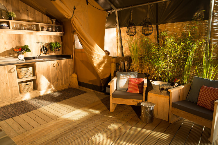 Acogedora área interior SunLodge Bintulu en Camping Village Poljana, Croacia, con muebles rústicos y plantas.