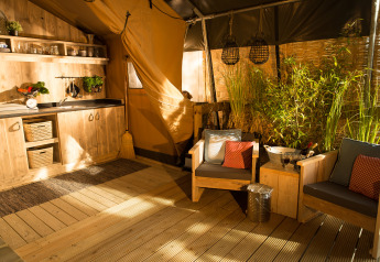 Intérieur lumineux de la SunLodge Bintulu au Camping Village Poljana en Croatie, avec meubles en bois et plantes.