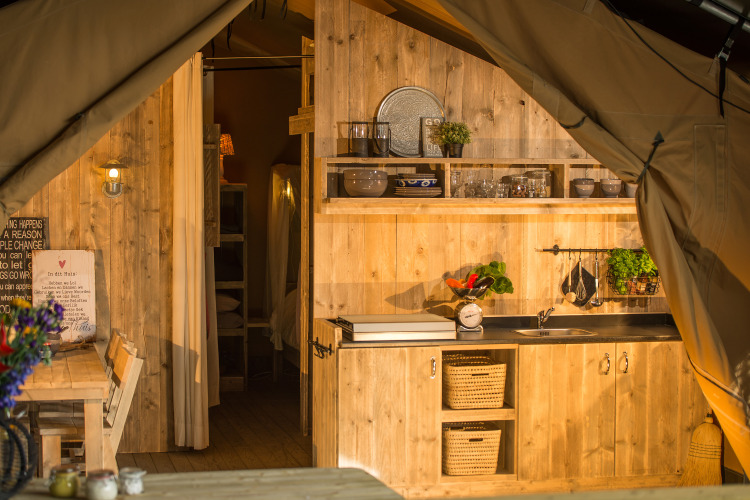 Acogedora cocina y comedor de madera en SunLodge Bintulu, Camping Village Poljana, Croacia, al atardecer.