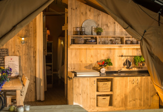 Acogedora cocina y comedor de madera en SunLodge Bintulu, Camping Village Poljana, Croacia, al atardecer.