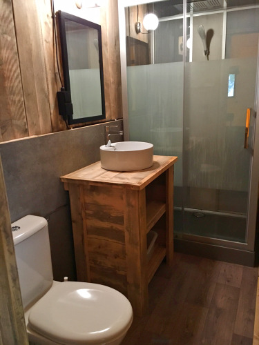 Baño rústico con paneles de madera, lavabo redondo, inodoro y ducha en SunLodge Bintulu, Croacia.