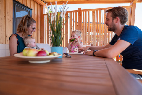 Gezin eet samen buiten op het terras van SunLodge Catalpa bij Camping Village Poljana in Kroatië.