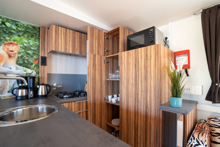 Moderne keuken bij SunLodge Catalpa met houten kasten, apparatuur en apenafbeelding aan de muur.