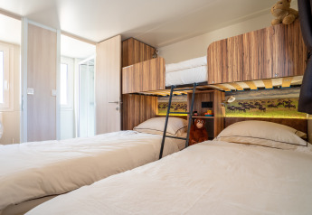 Camera SunLodge Catalpa con due letti singoli, letto a castello, arredo in legno e peluche per bambini.