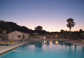 Swimmingpool ved solnedgang på Camping Leï Suves feriepark i Provence-Alpes-Côte d'Azur, Frankrig.