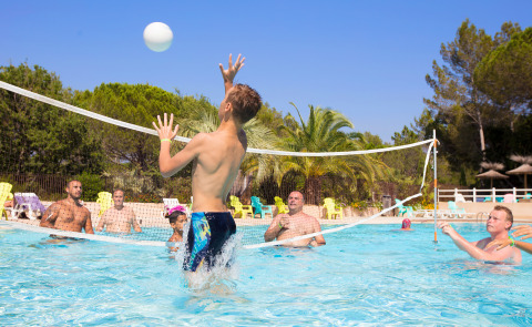 Folk spiller vandvolleyball i en pool under solrige forhold på Camping Leï Suves i Provence-Alpes-Côte d’Azur.