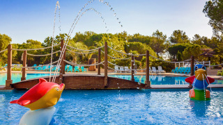 Piscina infantil con figuras de animales y fuentes de agua en Camping Leï Suves, Provenza, Francia.