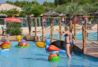 Bambini che giocano in una piscina bassa con giochi d'acqua colorati al Camping Leï Suves, Provence-Alpes-Côte d’Azur, Francia.