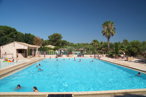 Swimmingpool på Camping Leï Suves i Provence-Alpes-Côte d’Azur, Frankrig, med gæster i sommersol.