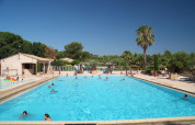 Swimmingpool på Camping Leï Suves i Provence-Alpes-Côte d’Azur, Frankrig, med gæster i sommersol.