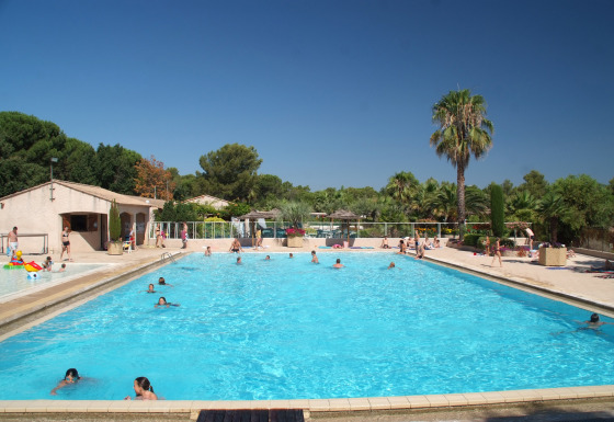 Swimmingpool på Camping Leï Suves i Provence-Alpes-Côte d’Azur, Frankrig, med gæster i sommersol.