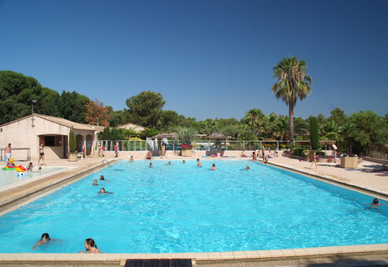 Piscina en Camping Leï Suves, Provenza-Alpes-Costa Azul, Francia, con personas disfrutando del verano.