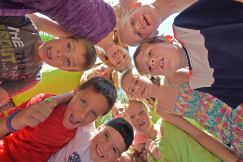 Niños felices reunidos en círculo al aire libre en Camping Leï Suves, Provenza-Alpes-Costa Azul, Francia.