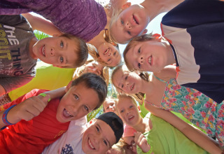 Niños felices reunidos en círculo al aire libre en Camping Leï Suves, Provenza-Alpes-Costa Azul, Francia.