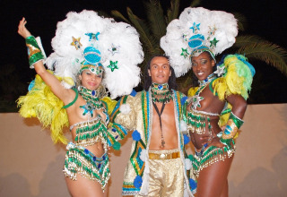 Tre dansere i farverige kostumer til karneval på Camping Leï Suves i Provence-Alpes-Côte d’Azur, Frankrig.