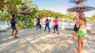 Grupo participando en actividad de fitness al aire libre en Camping Leï Suves en Provenza, Francia.
