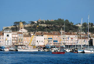 Udsigt over havnen i Provence-Alpes-Côte d’Azur med farverige bygninger og lystbåde ved Camping Leï Suves.