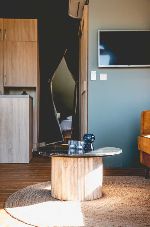 Moderne leefruimte in een luxe safaritent bij Camping de Bovenberg in Nederland met tafel en tv.