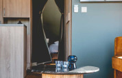 Sala moderna en una tienda safari de lujo en Camping de Bovenberg, Países Bajos, con mesa y televisión.