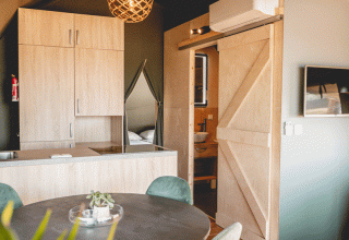 Innenansicht eines luxuriösen Safarizelts mit moderner Einrichtung auf Camping de Bovenberg, Niederlande.