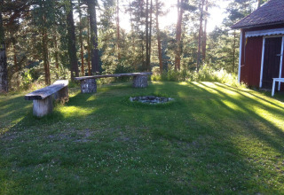 Panchine all’aperto e zona fuoco nel verde di Småland Miniglamping, Kalmar län, Svezia.