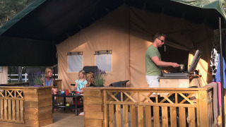 Familia disfruta vida al aire libre en terraza de madera en Småland Miniglamping, Kalmar län, Suecia.