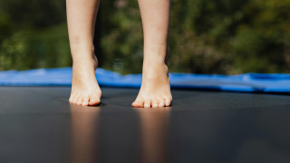 Persona descalza de pie en una cama elástica en Småland Miniglamping, Kalmar län, Suecia.