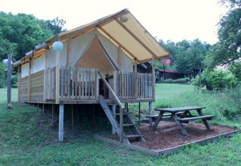 Safaritent bij Camping Sretanwolf in Kroatië, verhoogde houten veranda en picknicktafel in de natuur.