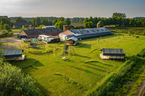 Luftaufnahme des Hoeve Klein Haneveld Ferienparks in Nordbrabant, Niederlande, mit Wiesen und Gebäuden.