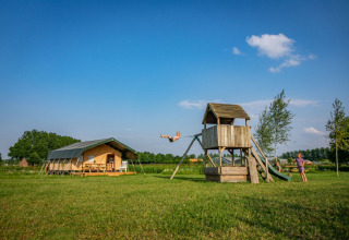 Bambini che giocano su un parco giochi vicino a una tenda safari a Hoeve Klein Haneveld, Brabante Settentrionale, Paesi Bassi.
