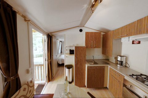Binnenzicht van de SunLodge Maple glamping accommodatie met moderne keuken en zicht op de slaapkamer.