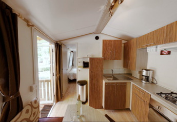 Binnenzicht van de SunLodge Maple glamping accommodatie met moderne keuken en zicht op de slaapkamer.