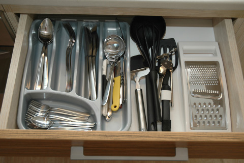 Cassetto delle posate al glamping SunLodge Maple con cucchiai, forchette, coltelli e utensili da cucina.