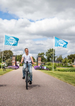 Padre e hijo pasean en bicicleta por Park Westerkogge, un parque vacacional en Holanda del Norte, Países Bajos.