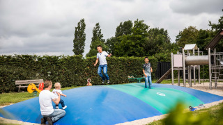 Niños y adultos juegan en un gran cojín inflable en el parque infantil de Park Westerkogge, en el norte de Holanda.