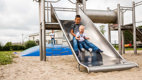 Deux enfants jouent ensemble sur un toboggan à Park Westerkogge, un parc de vacances en Hollande-Septentrionale.
