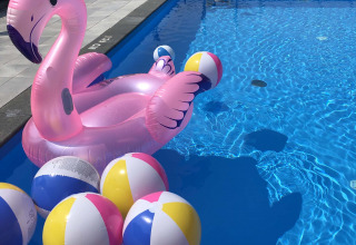 Schwimmbad mit aufblasbarem Flamingo und Strandbällen im Park Westerkogge, Nordholland, Niederlande.