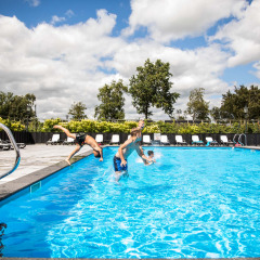 Dos niños saltan a la piscina exterior en Park Westerkogge, un parque vacacional en Holanda Septentrional, Países Bajos.