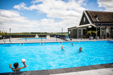 Niños juegan en la piscina exterior del parque vacacional Park Westerkogge en Holanda Septentrional, Países Bajos.