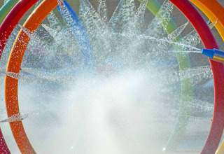 Aros de agua coloridos y chorros en la zona de juegos acuáticos de Camping Village Baia Blu La Tortuga, Cerdeña.