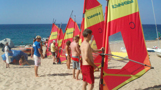 Huéspedes aprenden windsurf en la playa de Camping Village Baia Blu La Tortuga, Cerdeña, Italia.