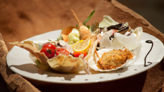 Plato gourmet con delicias italianas en Camping Village Baia Blu La Tortuga, Cerdeña, Italia.