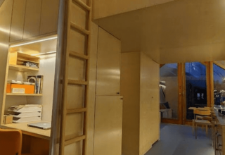 Vista interna del lodge Pentagon a Buytenplaets Suydersee nei Paesi Bassi, con arredo in legno chiaro.