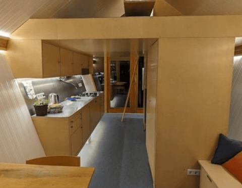 Binnenzicht van de Pentagon-lodge bij Buytenplaets Suydersee in Nederland, met moderne houten inrichting.