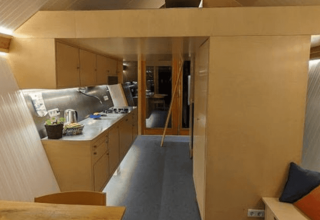 Binnenzicht van de Pentagon-lodge bij Buytenplaets Suydersee in Nederland, met moderne houten inrichting.